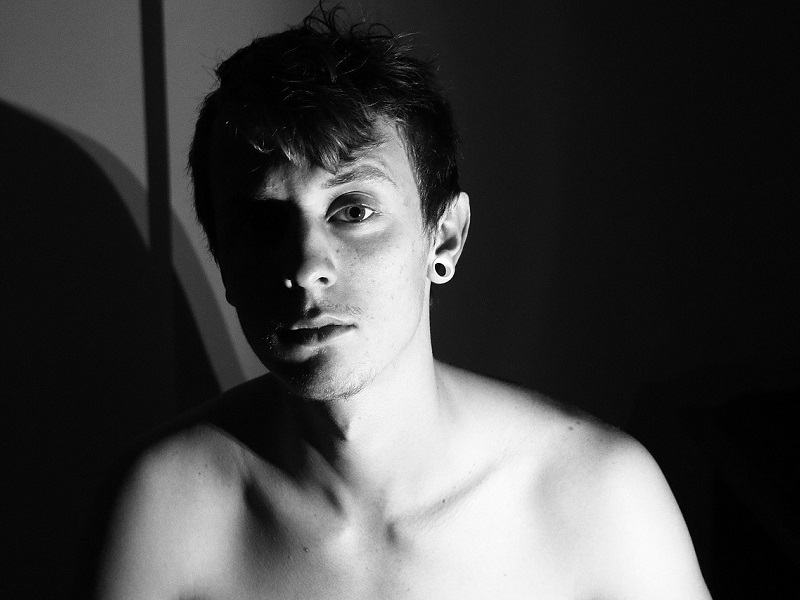 A young man sitting in the dark